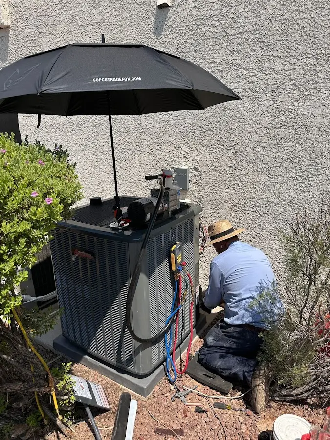 HVAC technician performing outdoor AC maintenance in Orange Cove